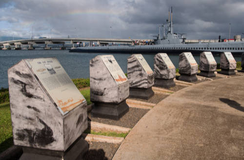 Visitors are guided through a series of memorial plaques on a private Pearl Harbor tour.
