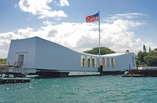 The USS Arizona Memorial rests atop the water in Pearl Harbor, marking the resting place of 1,102 sailors and Marines killed during the attack on Pearl Harbor.