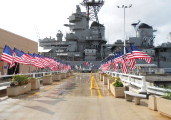 American flags line the boardwalk leading to USS Missouri, visitors gain access to this site and many others in our private Pearl Harbor tours.