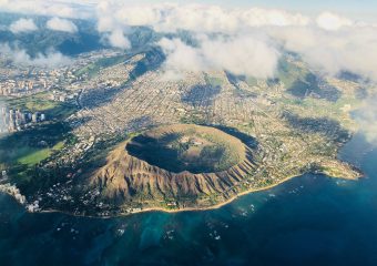 A beautiful aerial view shows Oahu rising from deep waters, as seen in our Circle Island and Honolulu tour.